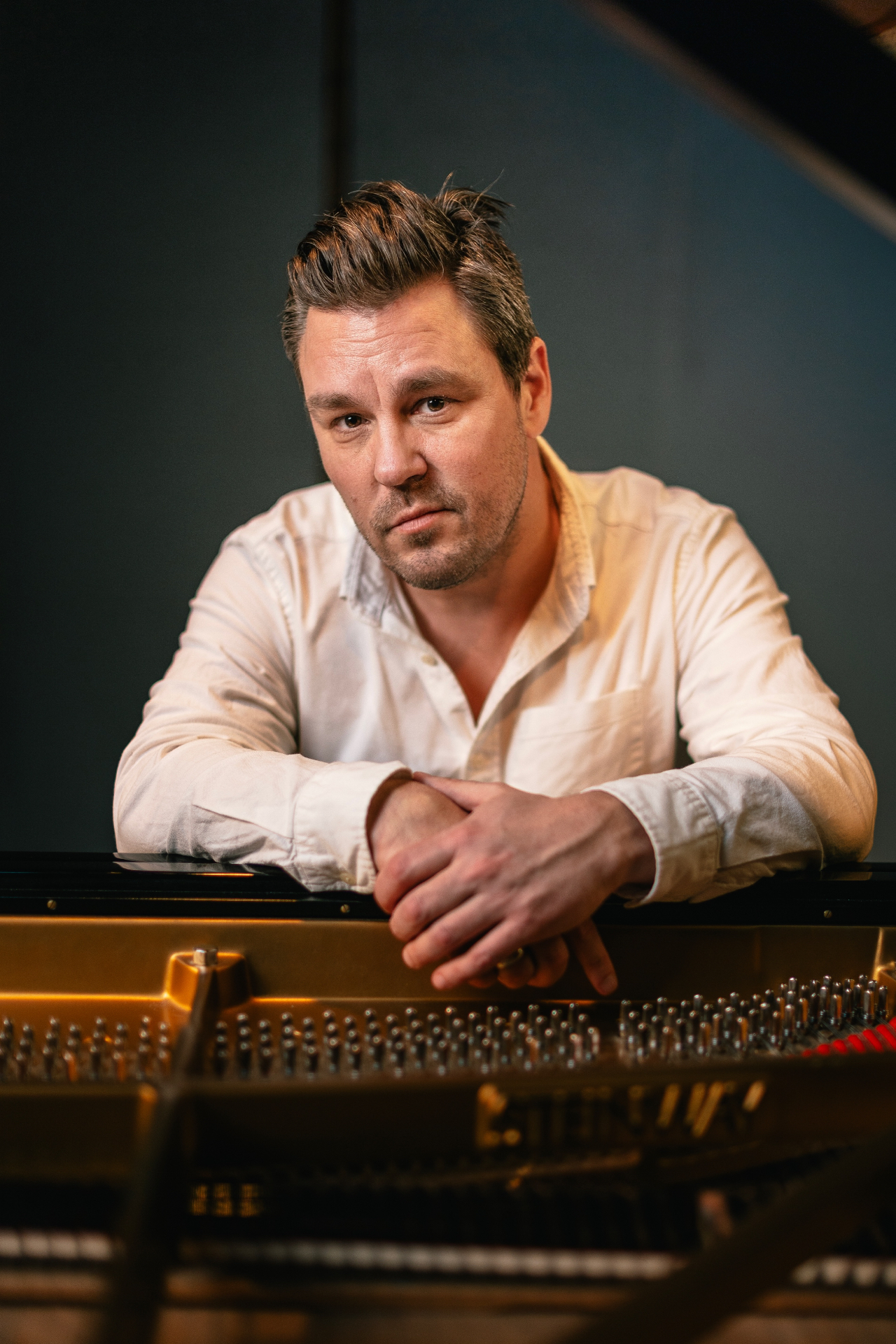 Nicolai Majland leaning on a grand piano
